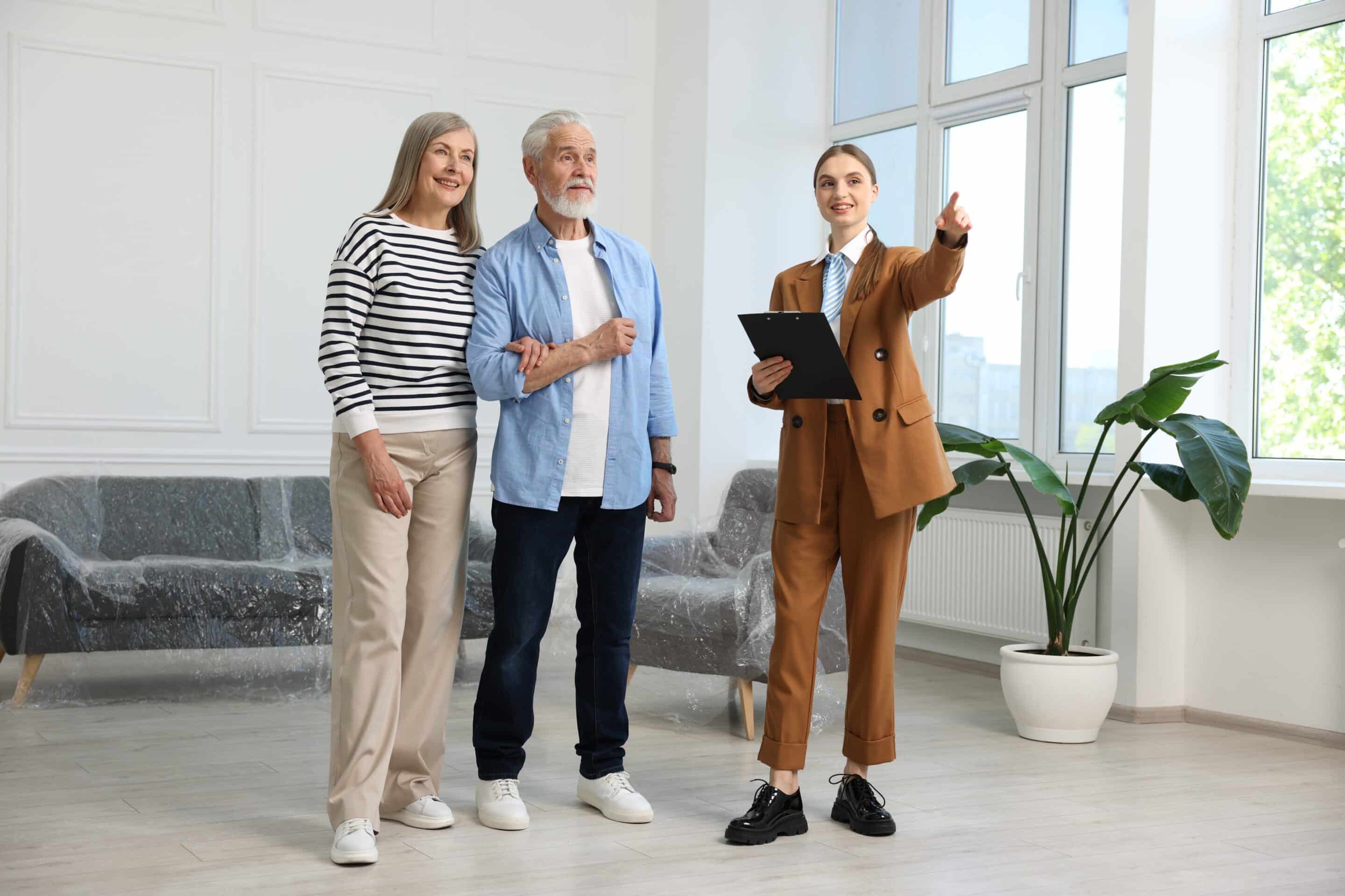 Lady estate agent showing clients around a house their estate agency is selling