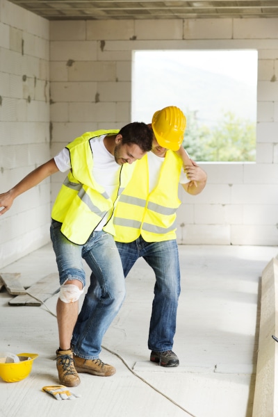 injured construction worker being helped by a colleague