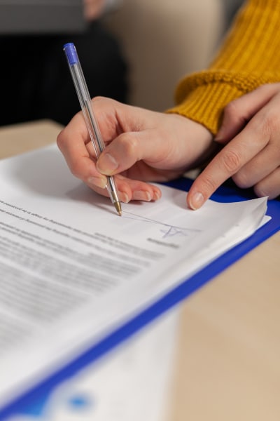 Woman signing a settlement agreement