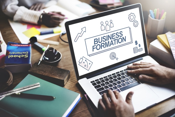 Solicitor working on laptop with client discussing Partnership and Company Formation