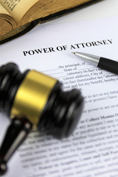 A Power of Attorney document wiht a gavel and pen sitting on top of it