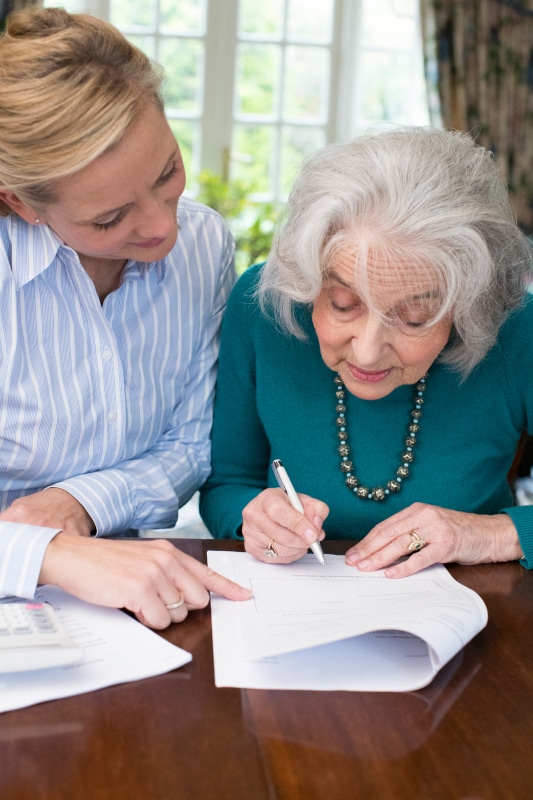 Mother and adult child discussing a Power of Attorney document at home in Scotland