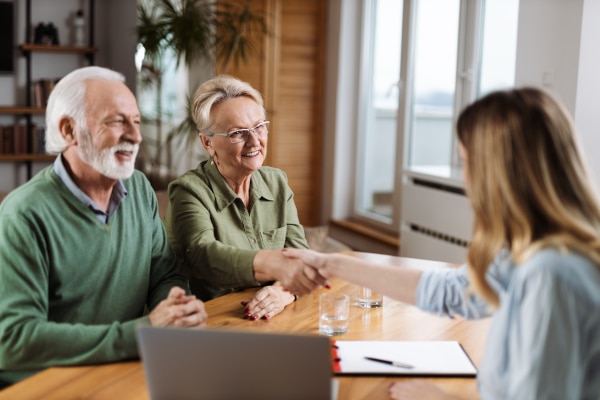 Solicitor explaining a Will to an older client across a desk in a professional office.
