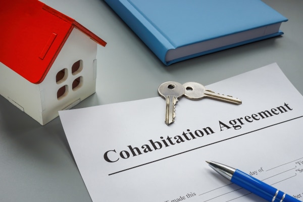 Cohabitation Agreement in Scotland sitting beside a model house, house keys and a notebook