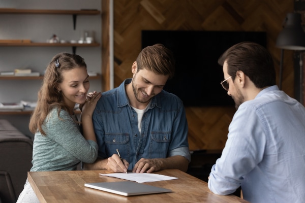 Young couple reviewing a Home Report with their solicitor before making an offer on a house in Scotland