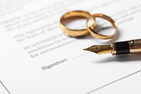Wedding rings on a legal document, reflecting how marriage and divorce affect a Will in Scotland