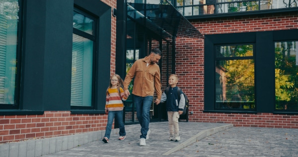 Parent collecting children from school, showing shared parental involvement after separation