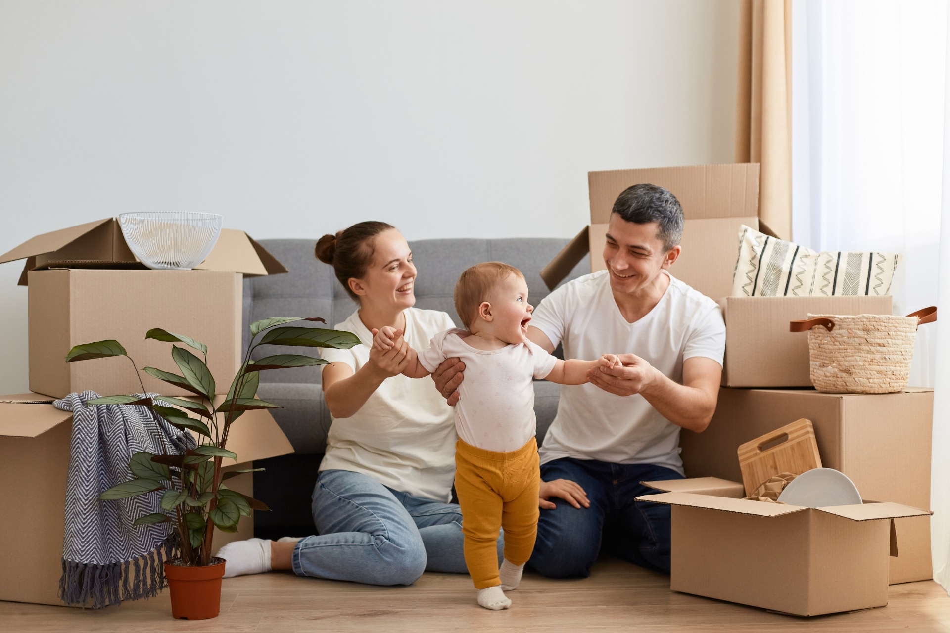 Young couple with their baby in a new home, a life stage when making a Will really matters