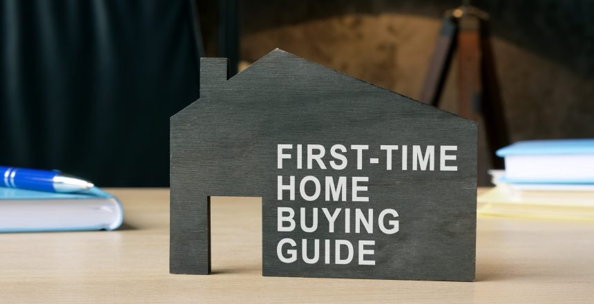 Dark model of home with sign first-time home buying guide.